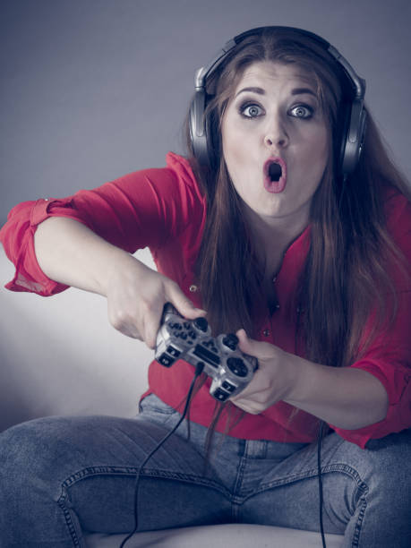 istock Young woman playing video games 1210736877