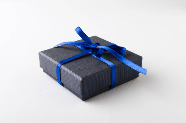 istock Closeup of wrapped blue gift box with bow on the white background 1210736941