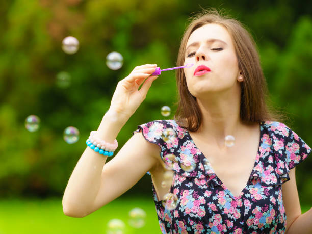 istock Woman blowing soap bubbles, having fun 1210738195