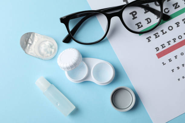 istock Glasses, contact lenses and eye test chart on blue background, top view 1210738283