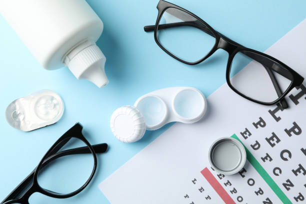 istock Glasses, contact lenses and eye test chart on blue background, top view 1210738559