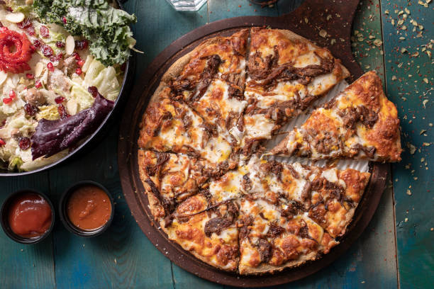 istock Roast beef pizza with colorful green salad 1210740021