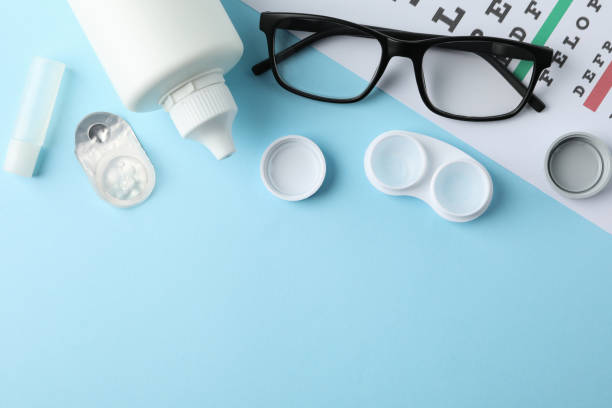 istock Glasses, contact lenses and eye test chart on blue background, top view 1210740065
