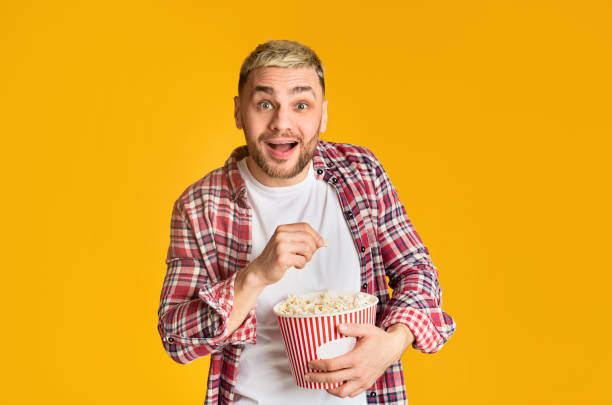 istock Guy watching movie emotionally and eating popcorn 1210741322
