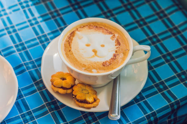 Coffee cup with cat face paint on the table.