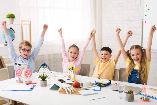 istock Finish robotic course. Children cheering and raising hands 1210742528