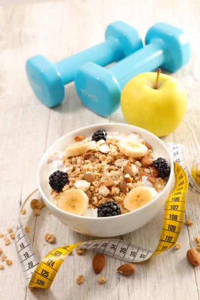 istock healthy breakfast- muesli with fruit, milk and dumbbell 1210742573
