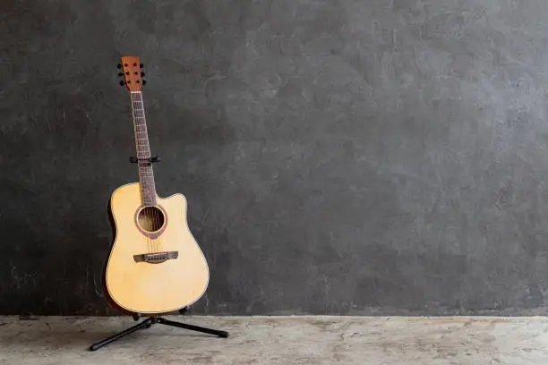 Photo of acoustic guitar on gray wall background