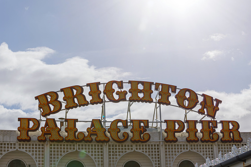 Brighton, England - February 26, 2020: People enjoying seaside on shingle beach by Brighton Pier.
