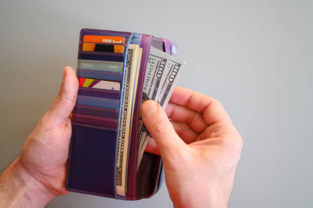 istock men's hands hold 100 dollar bills and a wallet on a gray background 1210746821