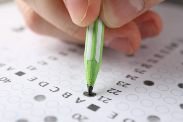 istock Student fills answers test sheet, close up 1210747173