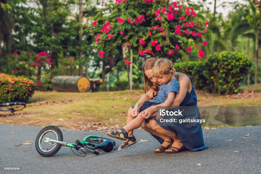 The Boy Fell Off The Bicycle His Mother Pastes A Plaster On His Knee Stock  Photo - Download Image Now - iStock