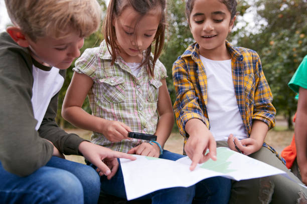 一緒に地図を見て屋外活動キャンプ旅行の子供のグループ - children only adventure exploration education ストックフォトと画像