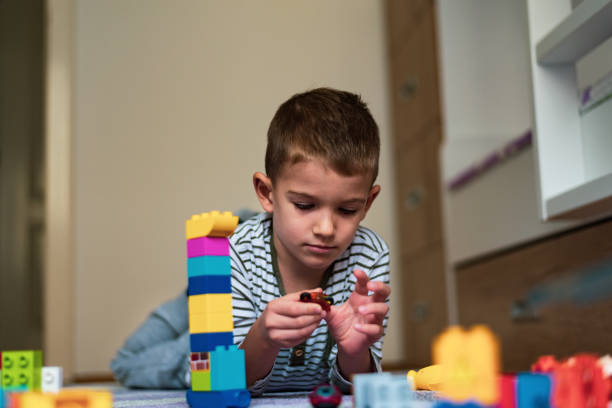 istock Happy boy playing with colorful building blocks 1210748700