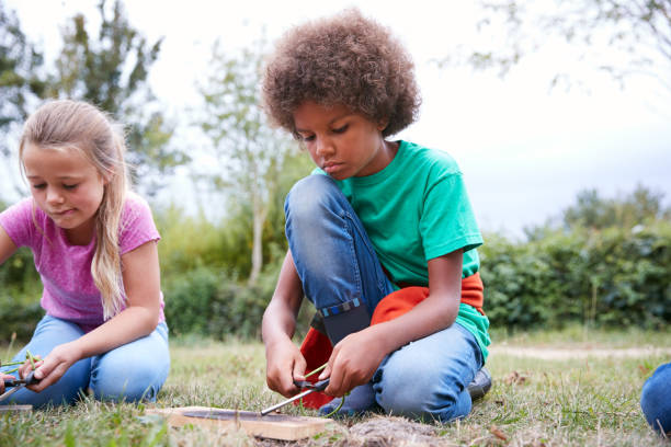 istock Two Children On Outdoor Camping Trip Learning How To Make Fire 1210749151
