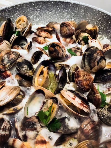 istock cooking clams in a stone pan using parsley and white wine. 1210749199