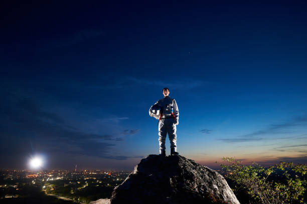 istock Space traveler standing on rocky mountain under night sky. 1210750276