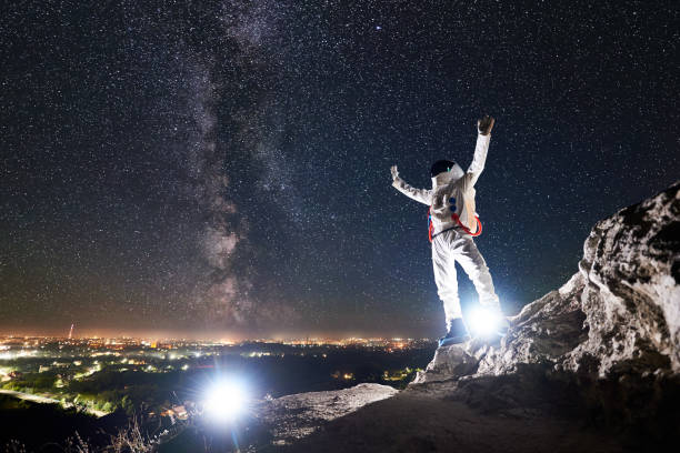 istock Astronaut standing under beautiful night sky with stars. 1210750345