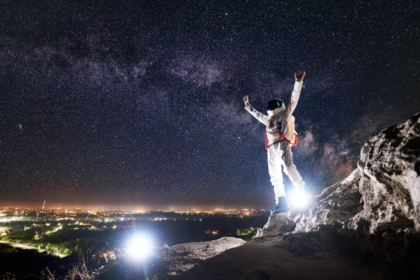 istock Astronaut standing under beautiful night sky with stars. 1210750363