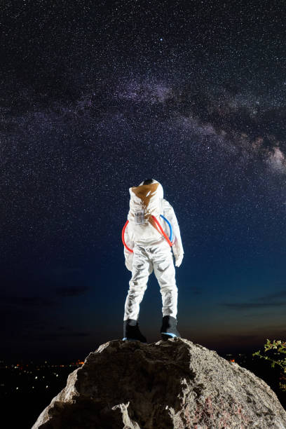 istock Astronaut standing on rocky mountain under starry sky. 1210750568