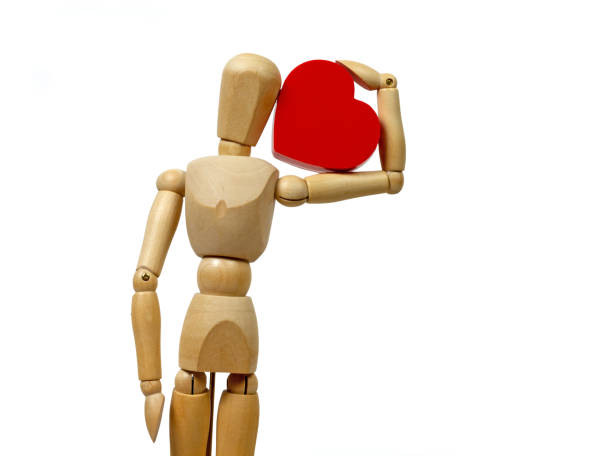 Wooden Mannequin Holding a Big Heart stock photo