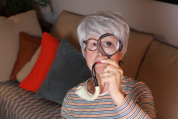 mujer mayor jugando al detective en casa - curiosity searching discovery home interior fotografías e imágenes de stock