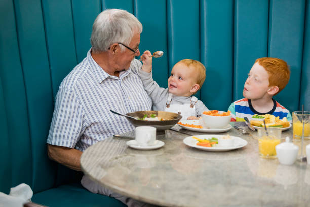 trzypokoleniowa rodzina jedząca lunch w restauracji - grandfather baby grandson grandparent zdjęcia i obrazy z banku zdjęć