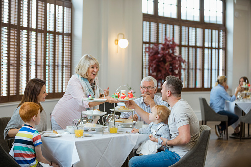 Grandparents, parents and children at afternoon tea together, food and drink, togetherness, weekend activities