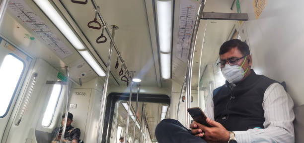 A man travelling in Delhi metro wearing a mask amid recent coronavirus outbreak in India's capital city. New Delhi, India . A man travelling in Delhi metro wearing a mask amid recent coronavirus outbreak in India's capital city. delhi metro stock pictures, royalty-free photos & images