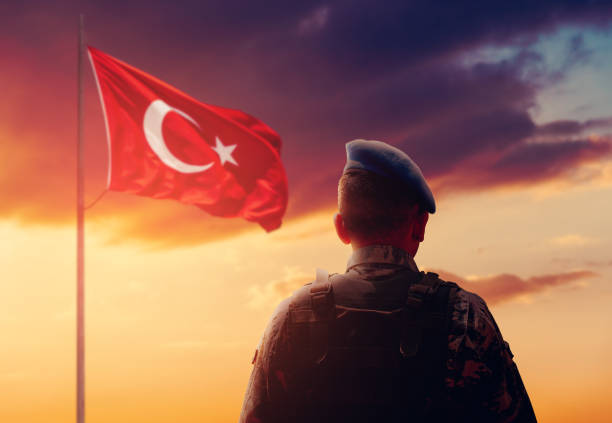 soldado turco está de pé e saudando a frente da bandeira turca em seu serviço de vigilância. - war symbols of peace conflict army - fotografias e filmes do acervo