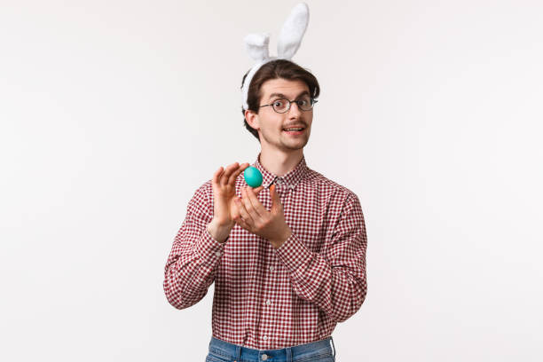 traditions, religious holidays, celebration concept. funny and cute bearded guy in glasses and rabbit ears introduce painted egg, prepare for easter day, feel proud, celebrating with family - mask religious celebration horizontal easter imagens e fotografias de stock