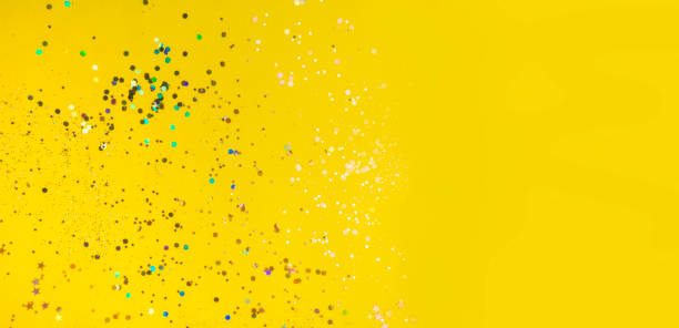 istock yellow background with colorful confetti 1210769324