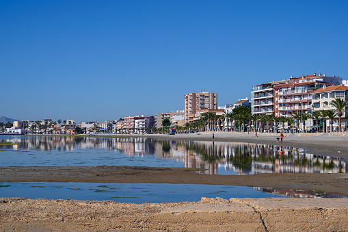 Beautiful calm day in the city Lo Pagan Spain. Reflections of the town in the lagoon Mar Menor. Popular tourist destination