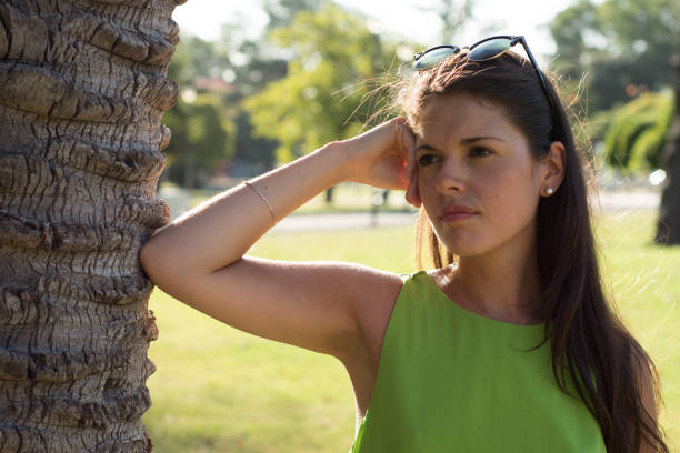 Woman portrait outdoors with green shirt in summer at the park
