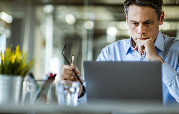 istock Thoughtful mid adult businessman working on a computer in the office. 1210771804