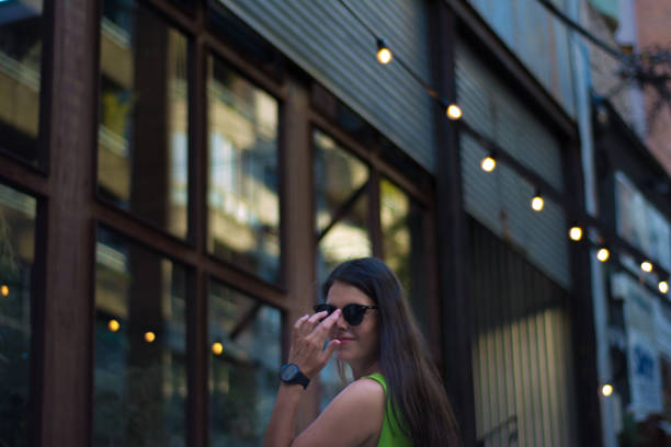 Woman portrait outdoors with green shirt in summer at the park