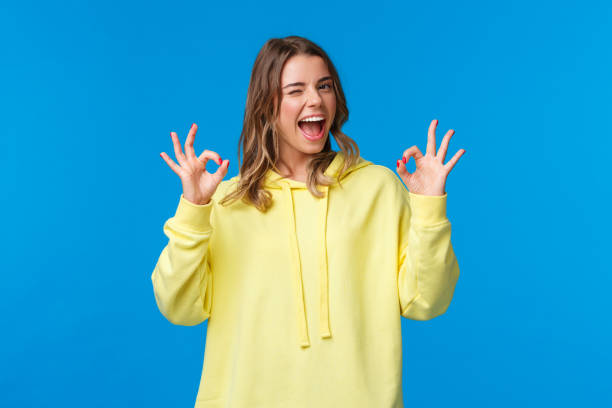 istock Girl assure she will deal with problem, nothing worry about. Blond female student guarantee everything good, wink and smiling relaxed, show okay gesture, standing blue background 1210772493