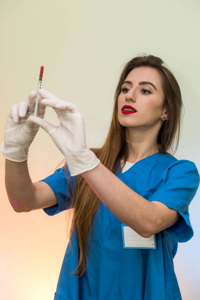 attraktive krankenschwester mit spritze immer bereit für die injektion. medizinisches thema - surgical glove human hand holding capsule stock-fotos und bilder