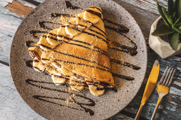 Chocolate pancake with bananas Chocolate pancake with bananas isolated on wooden background dessert sweet food stock pictures, royalty-free photos & images