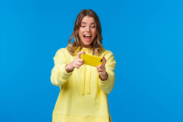 istock Girl turn smartphone sideways to pass level in racing game, using mobile phone on leisure time, having fun download cool new application, holding cellphone horizontally, laughing 1210773533