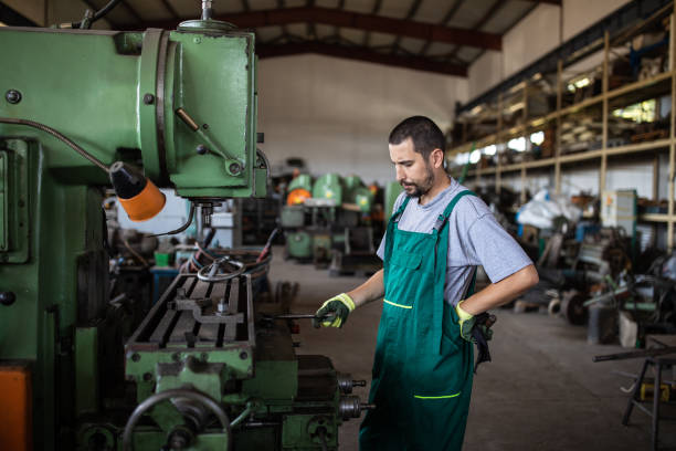 istock Young man operating machine at metal factory 1210773659
