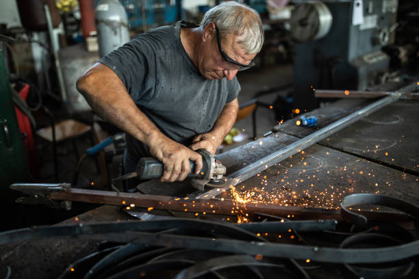istock Manual worker using angle grinder at metal factory 1210773676