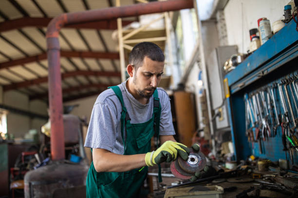 istock Young manual worker working at metal factory 1210773769