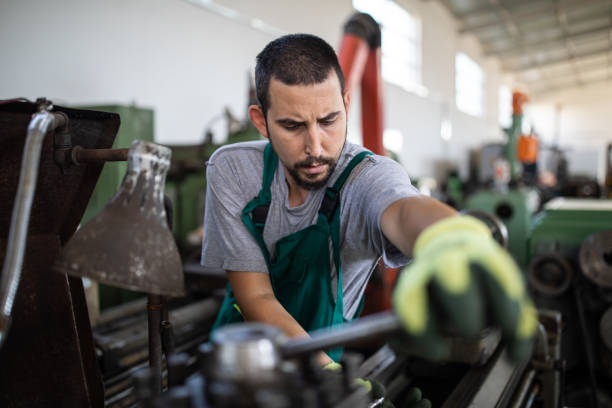 istock Young manual worker working at metal factory 1210773846