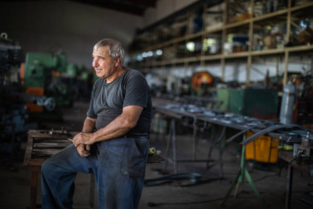 istock Manual worker taking a break and smoking cigarette at metal factory 1210773848