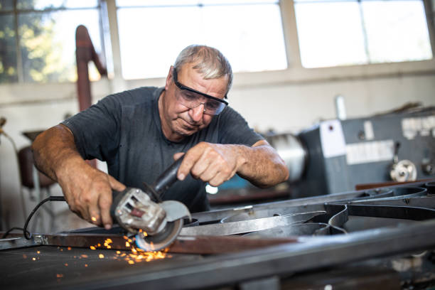 istock Industrial worker working with angle grinder at metal factory 1210774063