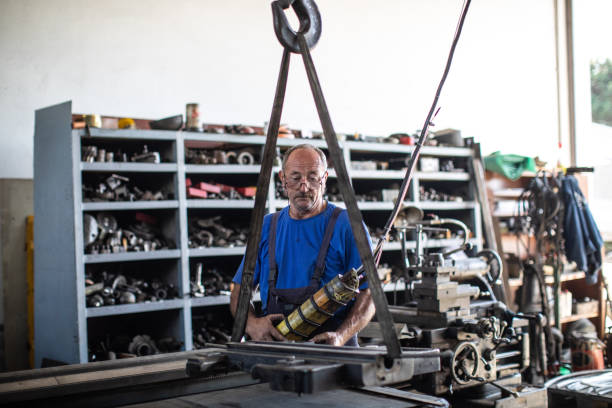 istock Industrial worker using machine at metal factory 1210774491