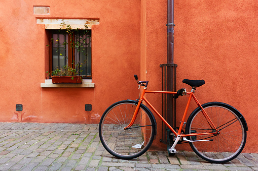 Red bicycle near old house in Rimini, Emilia-Romagna, Italy