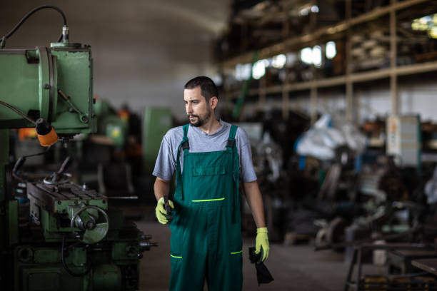 istock Young manual worker working at metal factory 1210774522