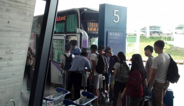 Taipei Taoyuan International Airport Bus Terminal In Taiwan China, People Boarding Bus View Of Advertisement Sign, Bus Driver Controlling Bus Ticket, People Standing. Looking Around, Talking To One Another, Queuing In Line For Bus Boarding At Taoyuan International Airport Bus Terminal In Taipei Taiwan China taiwan taoyuan international airport in taipei stock pictures, royalty-free photos & images